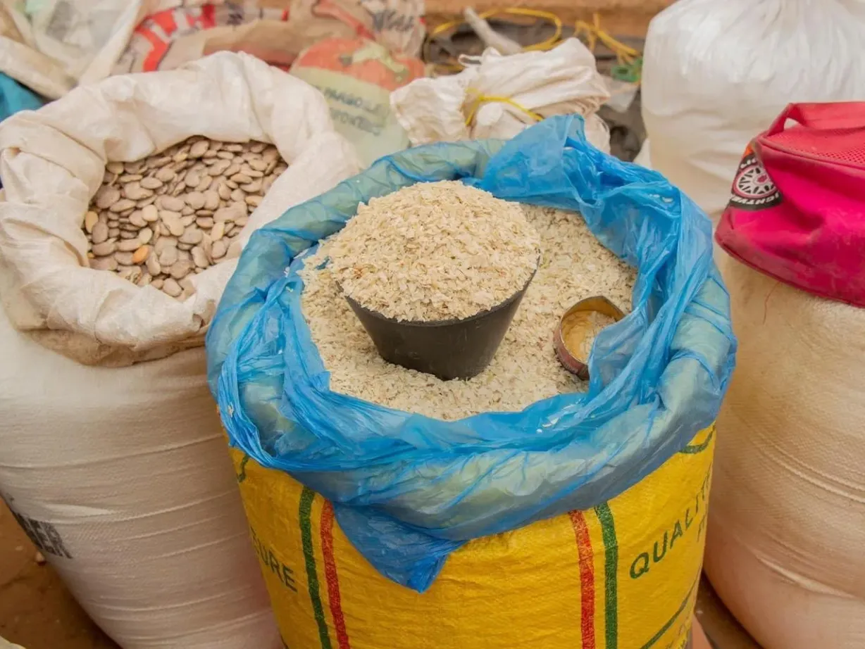 Mesure traditionnelle de produits sur un marché en Guinée